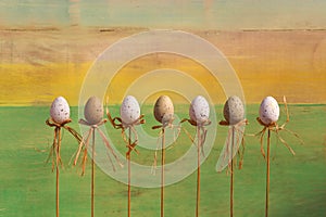 Happy Easter Eggs on Sticks Green Background
