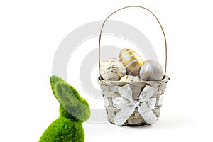 Happy Easter eggs white background. Golden shine decorated eggs and green bunny in basket, for greeting card, promotion
