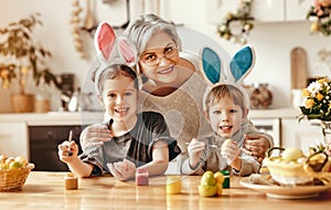 Happy easter! family   grandmother and children grandchildren paint eggs for holiday
