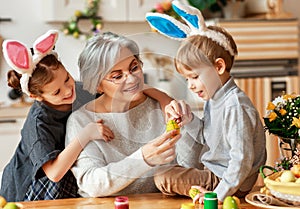 Happy easter! family   grandmother and children grandchildren paint eggs for holiday