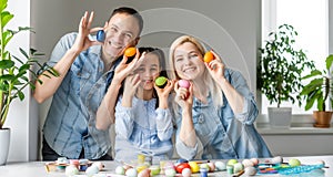 Happy easter! family mother, father and children having fun paint and decorate eggs for holiday