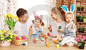 Happy easter! family mother, father and children paint eggs for