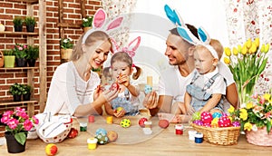 Happy easter! family mother, father and children paint eggs for