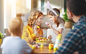 Happy easter! family mother, father and children paint eggs for holiday