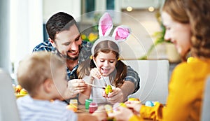 Happy easter! family mother, father and children paint eggs for holiday