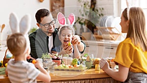 Happy easter! family mother, father and children paint eggs for holiday