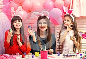 Happy easter family paint eggs. Easter, mother and children in pink bunny ears.