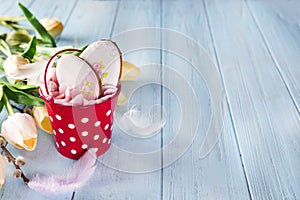 Happy Easter gingerbread cookie eggs with bucket on blue wood background,