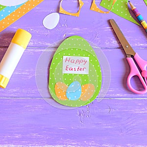 Happy Easter greeting card in egg shape. Easter card made from paper. Materials and tools for children`s creativity