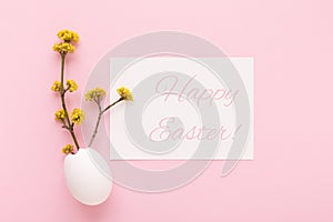 Happy easter holiday card with eggshell and spring branches.