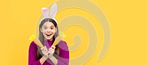 happy easter holiday. funny child in hare ears hold carrot. teenager girl wear rabbit costume. Easter child horizontal
