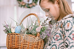 happy easter holiday time in spring season. little eight year old kid girl holds basket with painted eggs