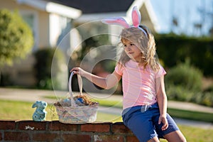 Happy Easter. Kids in bunny ears with Easter egg in basket. Boy play in hunting eggs. Easter holiday.