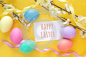 Happy Easter message with Easter eggs and apple tree branch on y