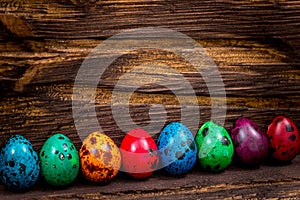 Happy Easter. painted eggs of different colors on a wooden table, Holiday decoration, Place for text