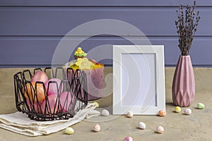 Happy easter. Painted pink eggs in a metal basket on a light background. Still life. Easter and spring holiday concept