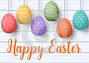 Happy Easter. pending easter eggs on white wooden background. Easter colorful hanging eggs