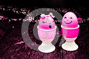 Happy easter pink eggs with painted drawn cartoon faces on black shiny background. Boy gives girl rose flower. Simplicity concept