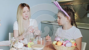 Happy Easter. Preparing the family for Easter. Mother with her daughter paints Easter eggs.