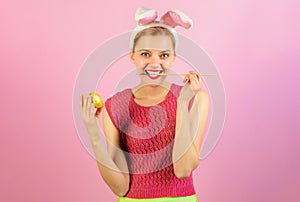 Happy Easter. Smiling girl in bunny ears painting egg for Easter holiday. Easter egg ideas. Bunny woman in rabbit ears