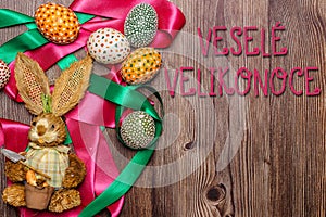 Happy Easter Text Message in Czech.Colorful hand painted decorated Easter eggs and bunny.Handmade Easter eggs on wooden table.