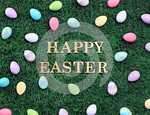 Happy Easter text surrounded with colorful Easter eggs on grass