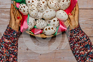 Happy Easter. Woman Hands holding basket with hand made decorated Easter eggs.Spring decoration background. Festive tradition for