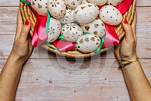 Happy Easter. Woman Hands holding basket with hand made decorated Easter eggs.Spring decoration background. Festive tradition for