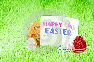 Happy Easter word on Open notebook on green grass with colorful