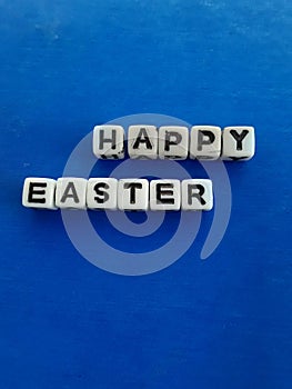 Happy Easter words letters on white blocks on a blue background