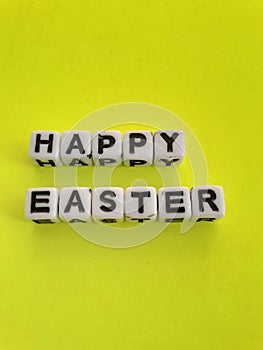 Happy Easter words letters on white blocks on a yellow background