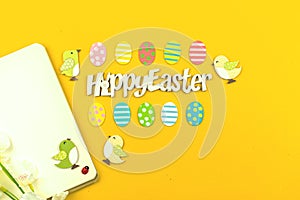 Happy Easter workspace background with text message and easter decoration, painted eggs and flat lay design