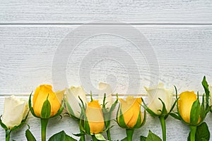 Happy Easter. Yellow and white roses on white wooden background. Easter background with copy space. Floral pattern. Greeting card