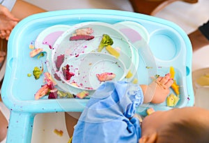 Happy eating Asian baby boy, 7 months old eating with Baby Led Weaning BLW method, Self-Feeding