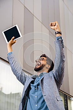 Happy ecstatic businessman with tablet