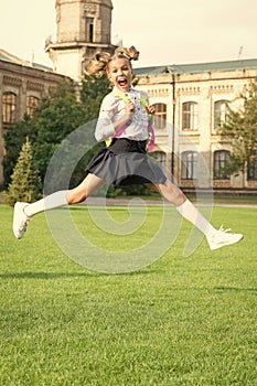 Happy ecstatic girl in uniform back to school jumping for joy, September 1