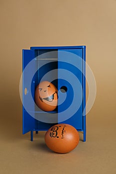 Happy egg hiding in closet and playing prank on another one against brown background