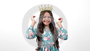 happy egocentric child in queen crown pointing thumb up on herself, egoistic