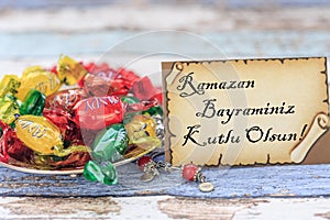Happy eid al fitr in turkish on the card with candies on vintage