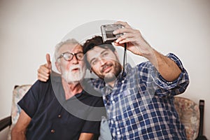 Happy elder, Son take a photo selfie with his uncle happy family with digital camera lifestyle