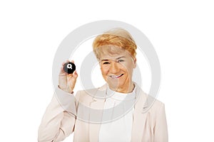 Happy elderly business woman holding eight billard-ball