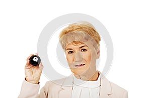 Happy elderly business woman holding eight billard-ball