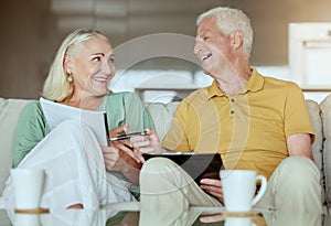 Happy elderly couple checking their finance and planning retirement. Senior caucasian man and woman smiling while