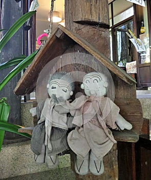 Happy elderly couple cloth dolls sitting in wooden cottage