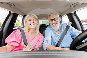 Happy elderly couple have car ride, taking selfie