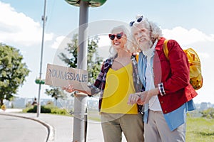 Happy elderly couple hitchhiking photo
