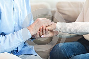 Happy elderly couple holding hands at home