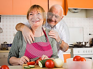 Happy elderly couple in kitchen