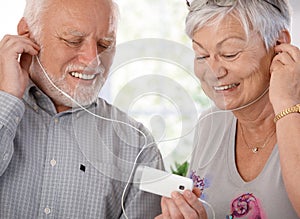 Happy elderly couple with mp3 player