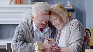 Happy elderly couple playing Board games in living room at home